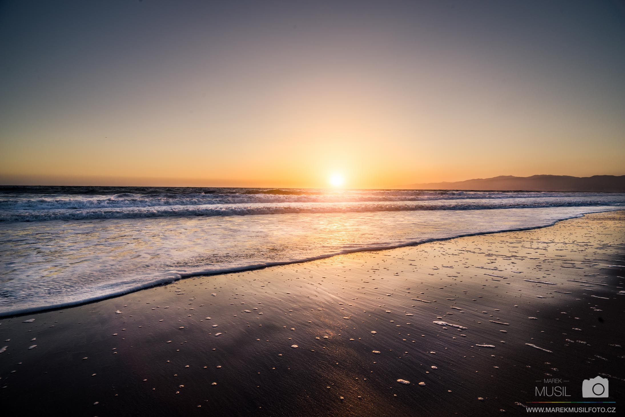 Západ slunce na pláži v Santa Monice.